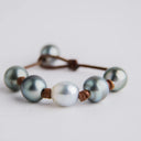Light Gray Tahitian and White South Sea Pearls knotted on Natural Leather Cord. Pearl Button Closure.