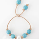 Turquoise with White South Sea Pearl knotted on Tan Leather Cord. Adjustable sliding closure.